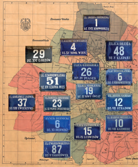 Na Planie orientacyjnym stoł. król. miasta Krakowa wydanym przez Budownictwo Miejskie w 1925 r.
(pierwsze wydanie w 1916 r.) kolekcja zachowanych jeszcze na frontonach kamienic emaliowanych tabliczek
orientacyjnych z numerami domów według wzoru wprowadzanego sukcesywnie w okresie międzywojennym
(numeracja domów wprowadzona w 1881 r. co do zasady nie zmieniała się, podział na dzielnice katastralne
także był stabilny, stąd możliwość równoległego utrzymywania dawnego – jeszcze z roku 1881 – i nowego
wzoru tych tabliczek. Powyżej przedstawiono stan istniejący do roku 1941, kiedy to do granic