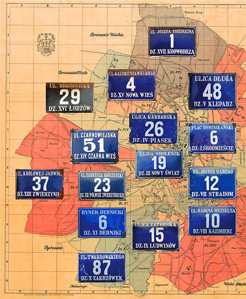 Fot. 37. Na Planie orientacyjnym stoł. król. miasta Krakowa wydanym przez Budownictwo Miejskie w 1925 r. (pierwsze wydanie w 1916 r.) kolekcja zachowanych jeszcze na frontonach kamienic emaliowanych tabliczek orientacyjnych z numerami domów według wzoru wprowadzanego sukcesywnie w okresie międzywojennym (numeracja domów wprowadzona w 1881 r. co do zasady nie zmieniała się, podział na dzielnice katastralne także był stabilny, stąd możliwość równoległego utrzymywania dawnego – jeszcze z roku 1881 – i nowego wzoru tych tabliczek. Powyżej przedstawiono stan istniejący do roku 1941, kiedy to do granic Krakowa przyłączono szereg terenów, z których utworzono nowe dzielnice katastralne, o kolejnych numerach od XIII do LII. W miarę integrowania tych nowych dzielnic z organizmem miejskim i tam pojawiły się tabliczki z numerami domów według tego wzoru. Sytuacja zmieniła się w związku z wprowadzeniem w 1954 r. podziału administracyjnego miasta na 6 dzielnic oraz zlikwidowaniem w 1955 r. podziału miasta na dzielnice katastralne – wówczas to wprowadzono nowy wzór tabliczek z nazwami nowych dzielnic (plan miasta: Biblioteka Jagiellońska, sygn. M 41/95)