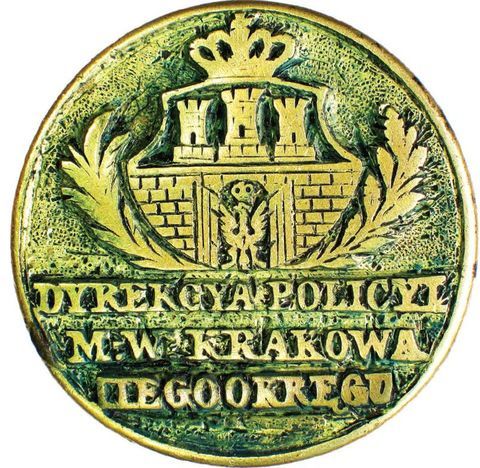 (018) Herb Krakowa i jednocześnie całej Rzeczypospolitej
Krakowskiej na pieczęci Dyrekcji Policji Wolnego Miasta
Krakowa, powołanej do życia w 1827 r., co pozwala w sposób
przybliżony datować tę pieczęć – tu zwierciadlane odbicie jej
stempla (ANK, sygn. T 8)